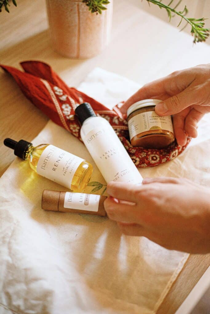 Woman holding affordable face cream bottle - daily skincare routine for glowing skin 2026