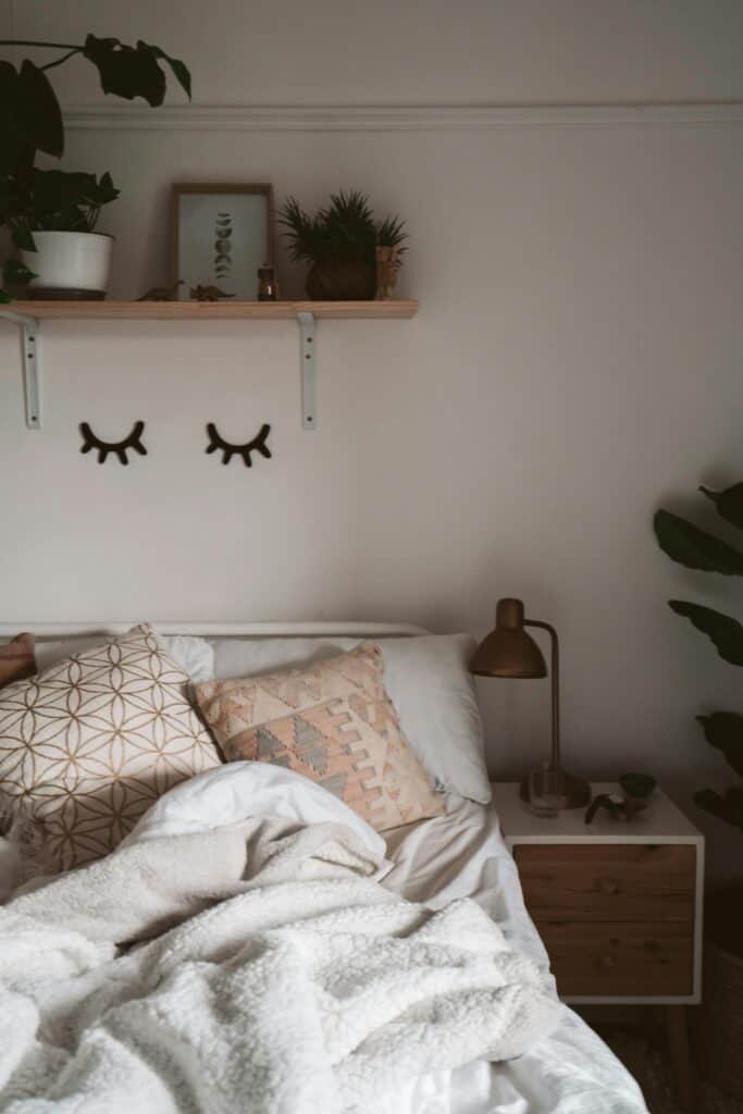 Cozy bedroom aesthetic with warm neutral tones knit blanket and lamp for affordable 2026 budget decor